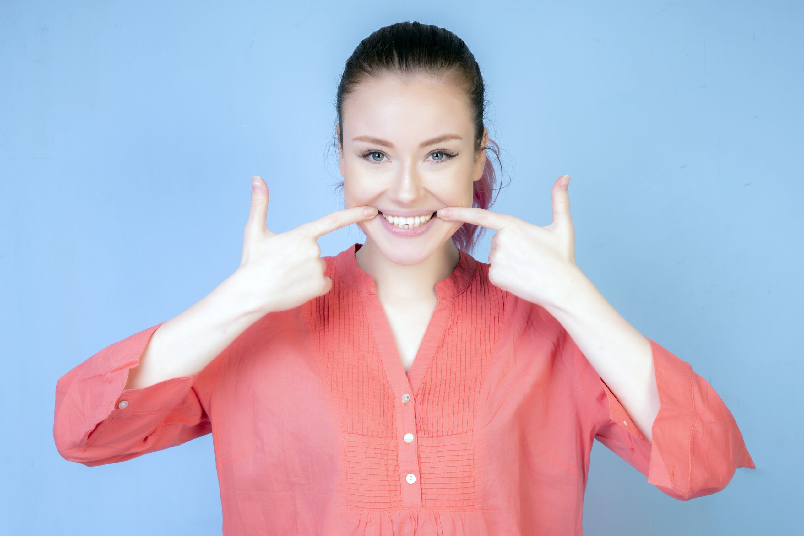 smiling girl with coral color blouse