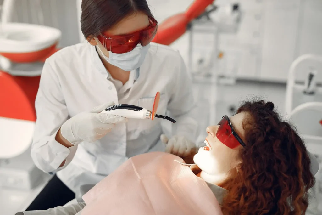 Dentist performing a teeth whitening procedure in a dental clinic.